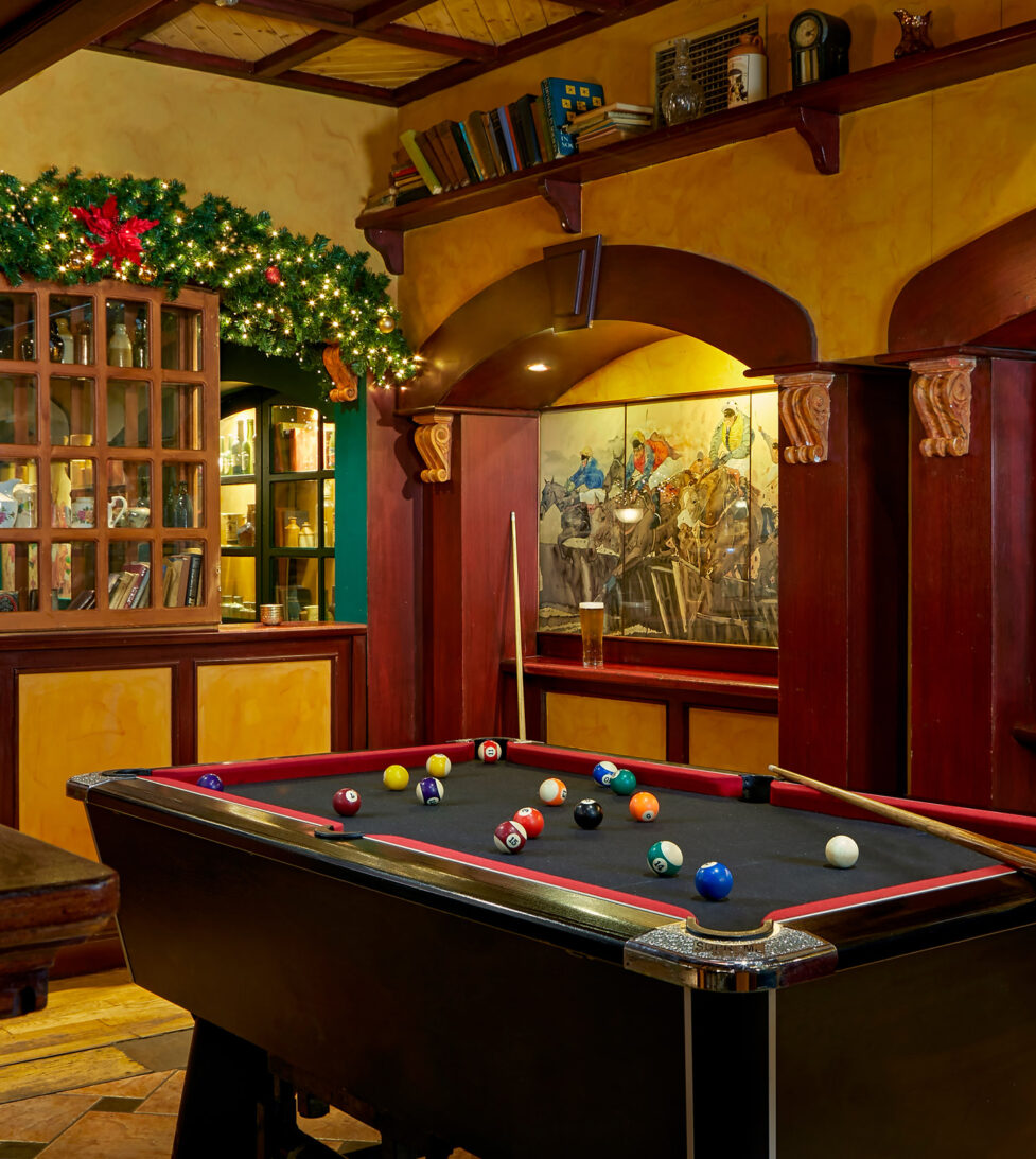 Cosy hotel games room with pool table and festive decor, perfect for relaxation and mingling.