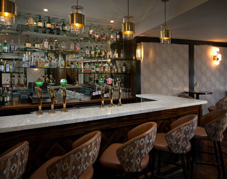 Stylish hotel bar with modern décor, a wide selection of drinks, plush seating, and ambient lighting for a relaxed evening.