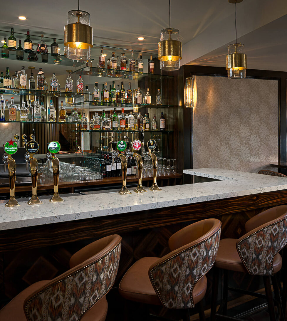 Stylish hotel bar with modern décor, a wide selection of drinks, plush seating, and ambient lighting for a relaxed evening.