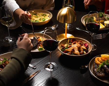 Elegant dining experience with gourmet dishes, ambient lighting, and fine wine at luxury hotel restaurant.