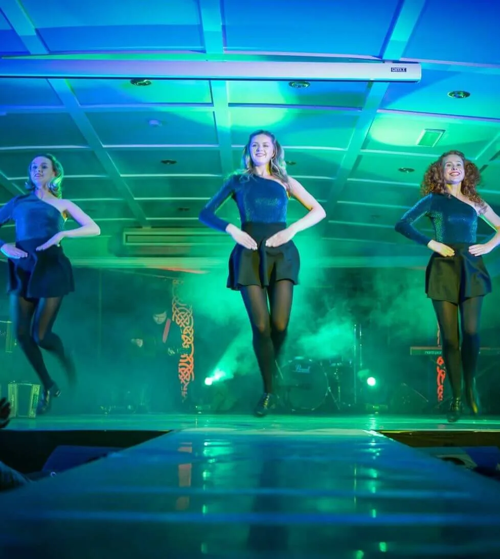 Lively Irish dance performance at hotel event showcasing vibrant lighting and energetic dancers.