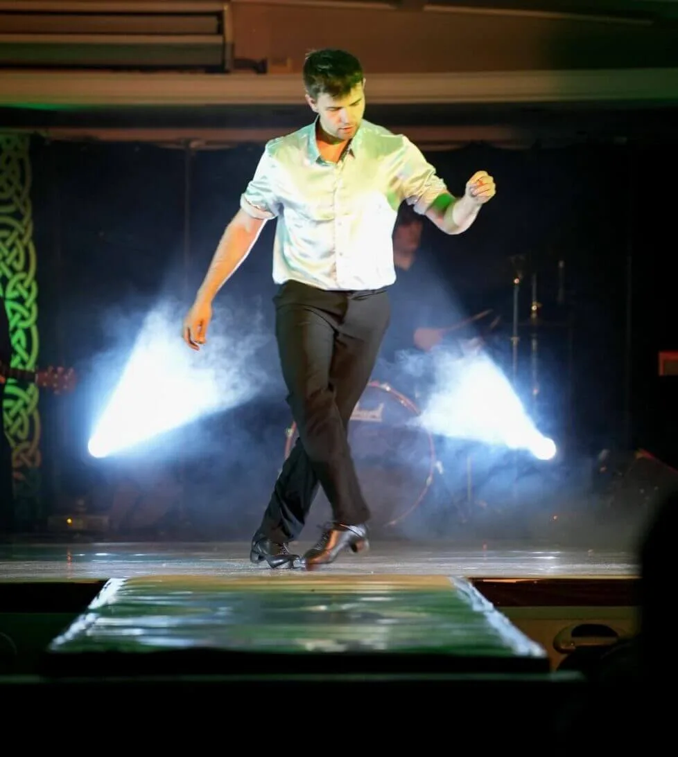 Dancer performing lively show on stage with vibrant lighting at hotel entertainment venue.