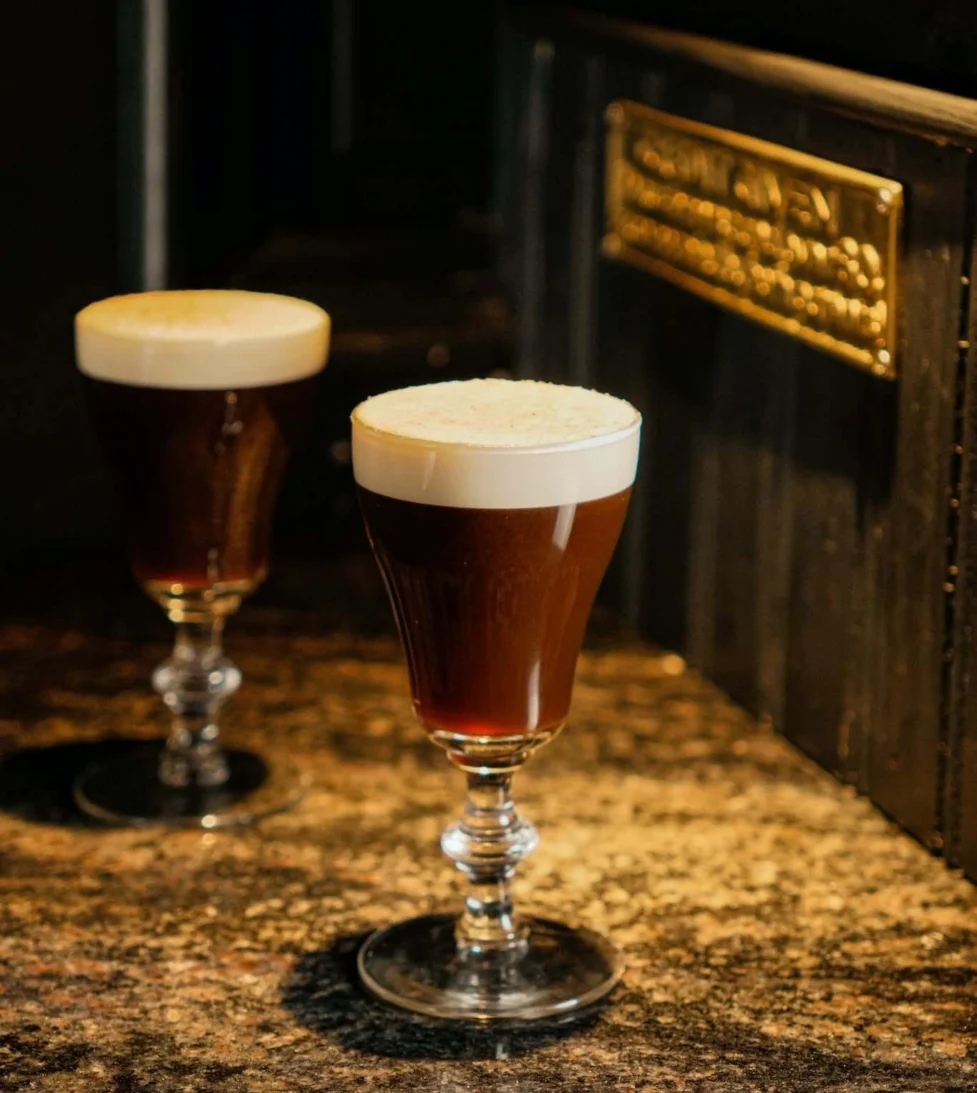 Cosy hotel bar with elegant Irish coffees on a marble counter, inviting atmosphere for relaxation and socialising.